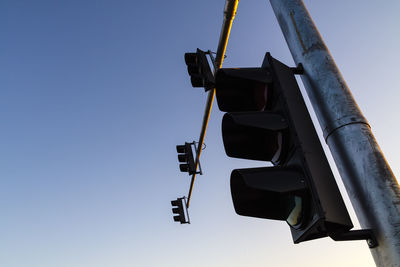 Low angle view of road signal against clear blue sky