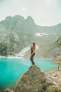 Side view of woman looking at mountain against sky