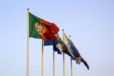 Low angle view of flags against clear sky