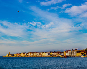 Scenic view of sea and buildings against sky