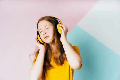 Girl listening music against abstract background