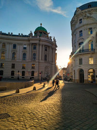 People walking on street against buildings in city