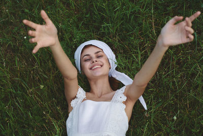 Portrait of young woman standing on grassy field