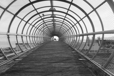 Rear view of man walking on footbridge