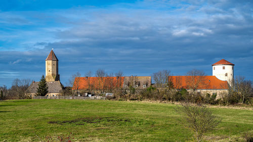 Built structures on field against sky