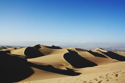 Scenic view of desert against clear blue sky