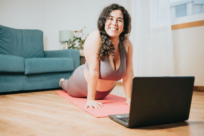 Young woman using laptop while sitting on table