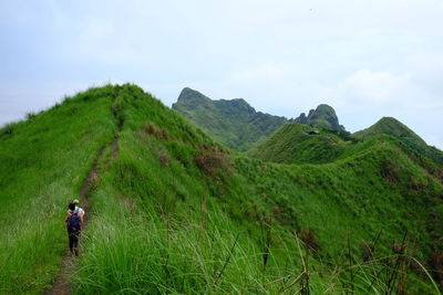 Rear view of hikers at mt batulao against sky