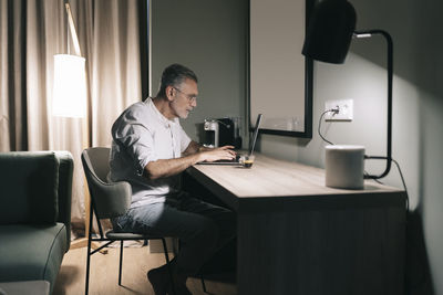 Man using mobile phone while sitting on chair