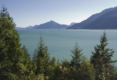 Scenic view of sea and mountains against clear sky