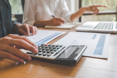 Cropped image of business colleagues working at desk in office