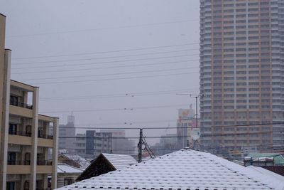 Buildings in city against sky during winter