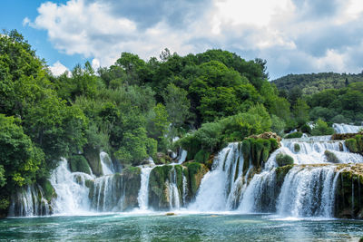 Scenic view of waterfall against sky