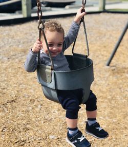 Full length of boy on swing at playground