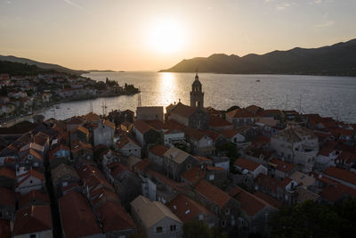 High angle view of townscape by sea against sky