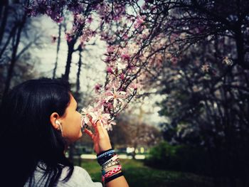 Woman smelling flowers in park