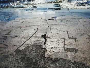 High angle view of text on wet land