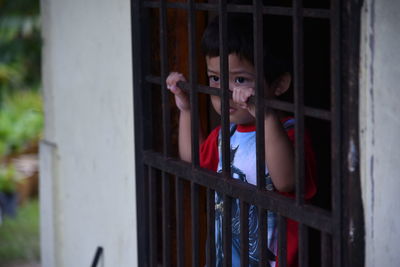 Cute boy looking through window