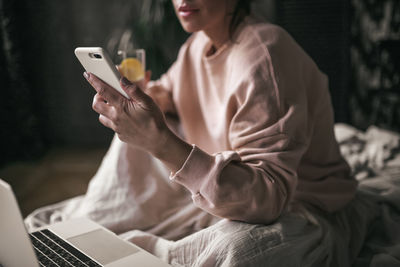 Midsection of woman using mobile phone