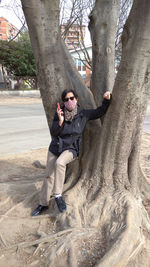 Man playing on tree trunk