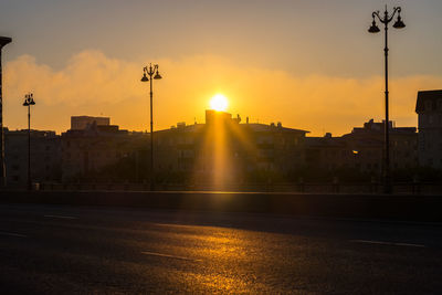 City street against sky during sunset