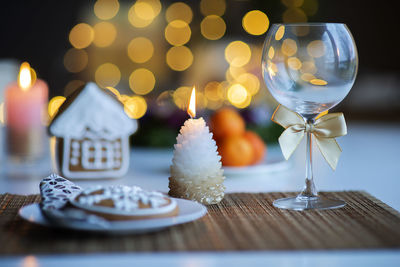 Festive christmas mood with a glass of wine and a burning candle on the kitchen dinner table