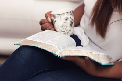 Low section of woman reading book