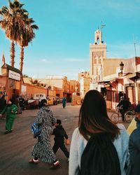 Rear view of people standing in front of building