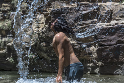 Shirtless man splashing water