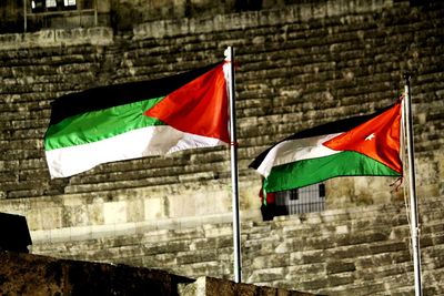 Low angle view of flag against built structure