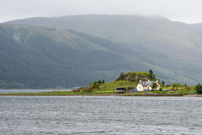 Scenic view of building and mountains against sky
