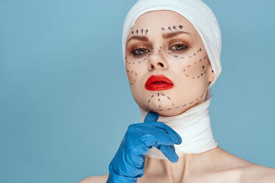 Portrait of woman against blue background