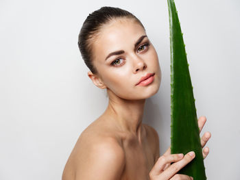 Portrait of a young woman making face against white background