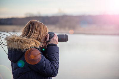 Woman photographing with umbrella