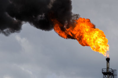 Oil refinery flare stack against sky