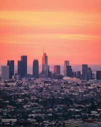 Modern buildings against sky during sunset