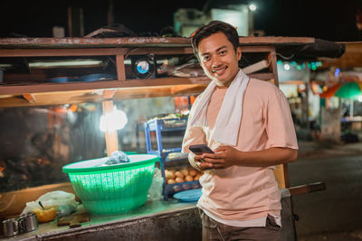 Portrait of smiling young man preparing food at home