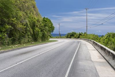 Road amidst trees against sky