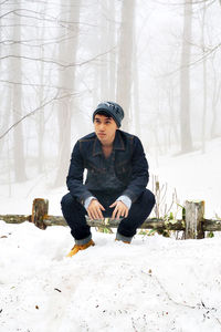 Full length of young man on snow covered field