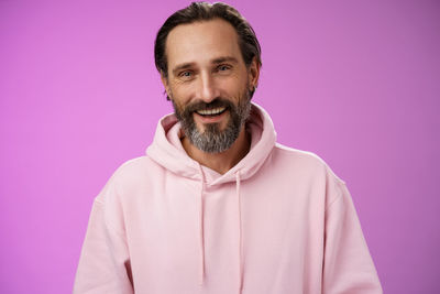 Smiling man against purple background