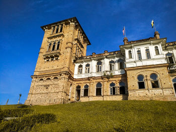 Low angle view of historic building against blue sky