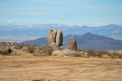 Rock formations on field against sky