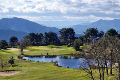 Scenic view of golf course against sky