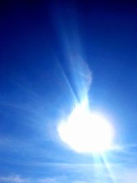 Low angle view of bright sun in sky