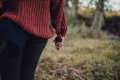 Midsection of woman standing in field