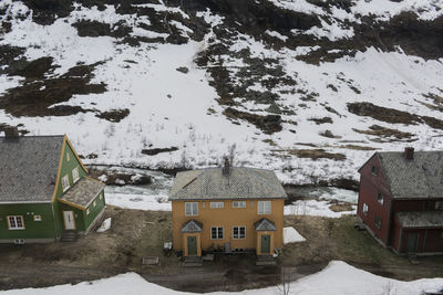 High angle view of snow covered houses by buildings