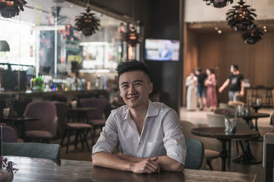 Portrait of young man sitting at restaurant