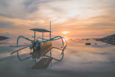 Lifeguard hut on beach against sky during sunset