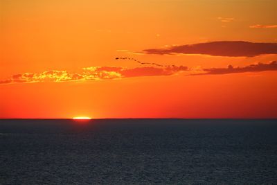 Scenic view of sea against romantic sky at sunset