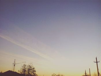 Silhouette electricity pylon against sky during sunset